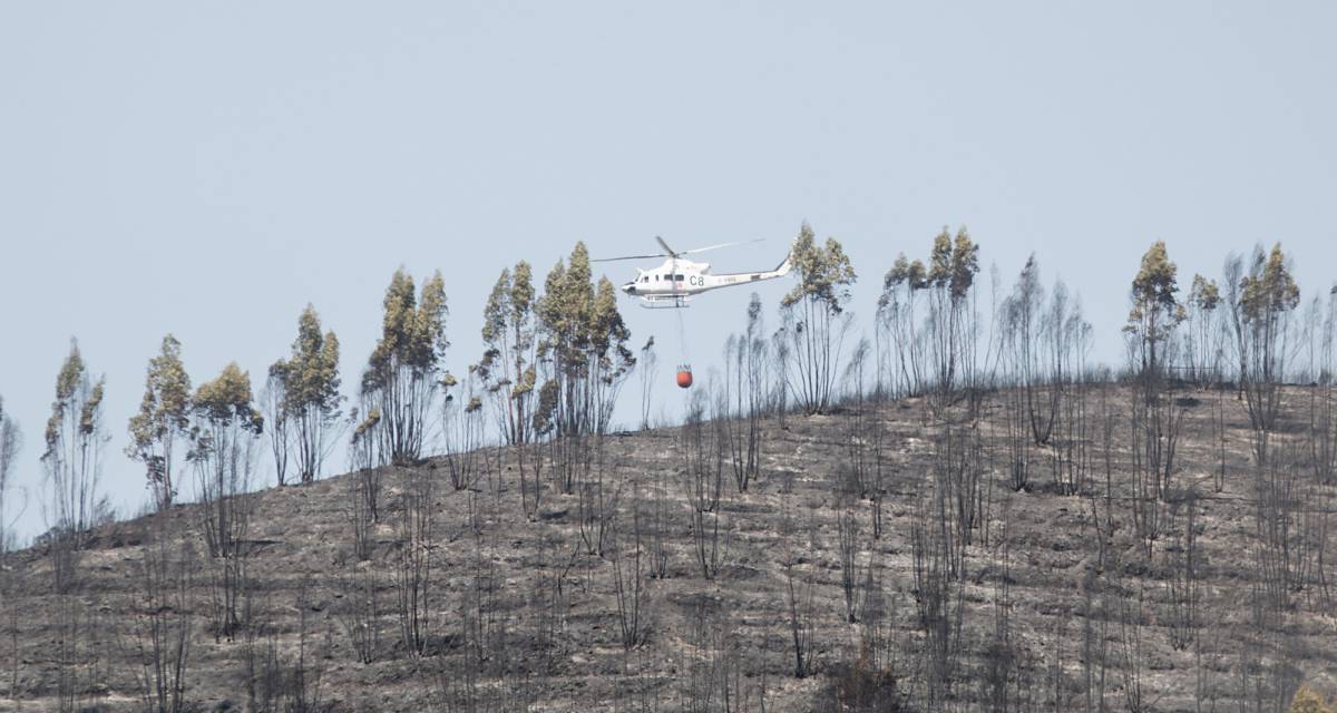 Un helic&oacute;ptero de Infoca sobrevuela una de las zonas afectadas por el incendio forestal.