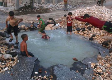 Ni&ntilde;os sirios se ba&ntilde;an en un agujero en Sheikh Saeed.