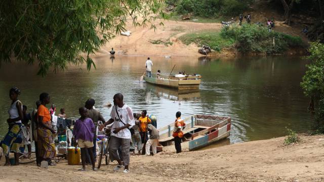 Varios viajeros cruzan un río en Liberia, uno de los países más pobres de África subsahariana.