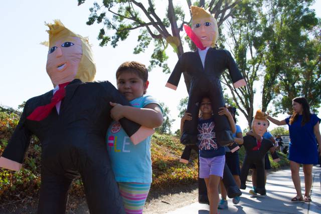 Hijas de inmigrantes protestan con piñatas de Donald Trump.