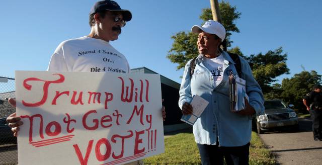 Un hombre con una pancarta contraria a Trump, en Detroit.