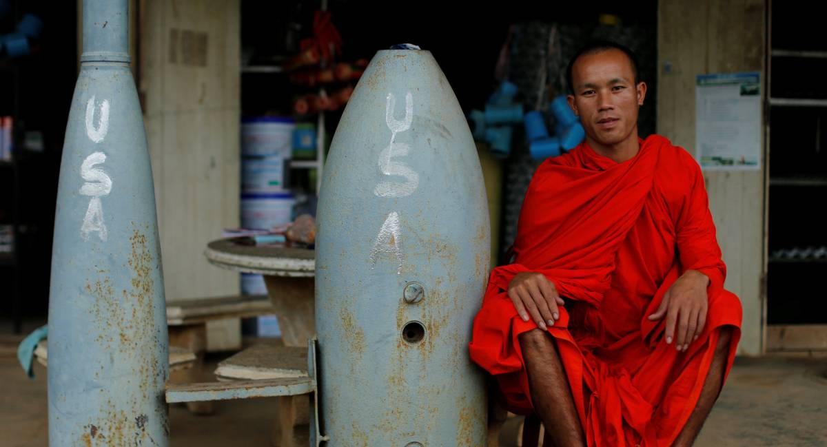 Monje budista posa junto a bombas sin explotar.