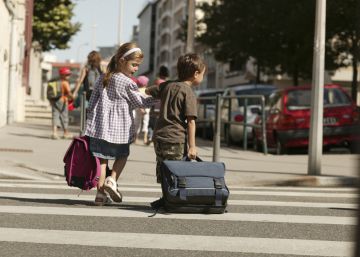 Ni&ntilde;os con sus pesadas mochilas se dirigen al colegio