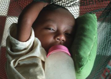 Un hu&eacute;rfano por culpa del sida, tumbado sobre una mosquitera.