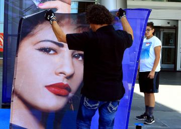 Un operario coloca el cartel de Selena Quintanilla en la tienda de MAC de Corpus Christi, Texas. 