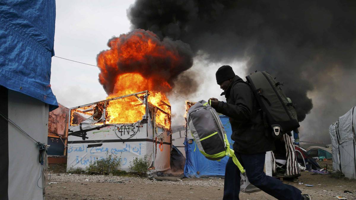 Un migrante transporta sus pertenencias en 'La Jungla' de Calais.