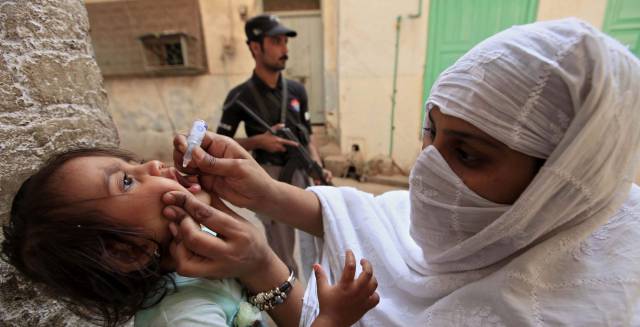 Una trabajadora vacuna contra la polio a una ni&ntilde;a el pasado jueves, en Peshawar (Pakist&aacute;n).