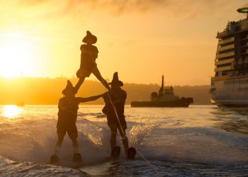 Varias personas practican esqu&iacute; acu&aacute;tico disfrazadas de brujas, en el puerto de Sydney (Australia).