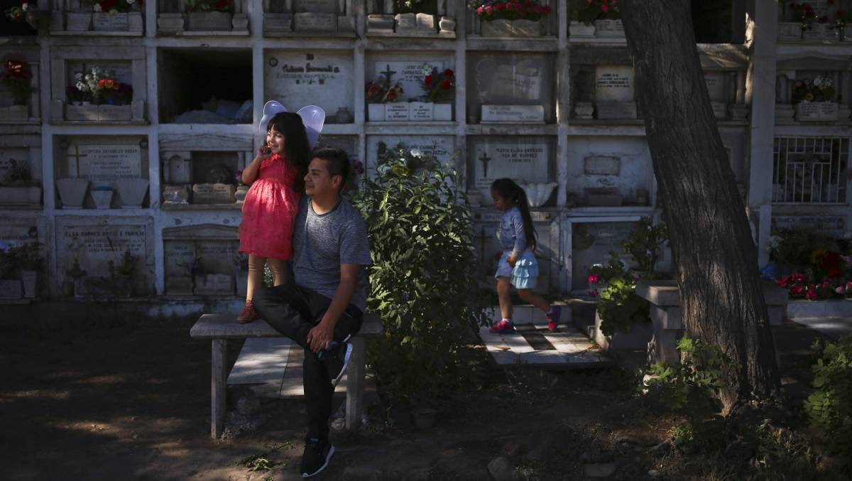 Un hombre visita la tumba de su padre en Santiago (Chile).