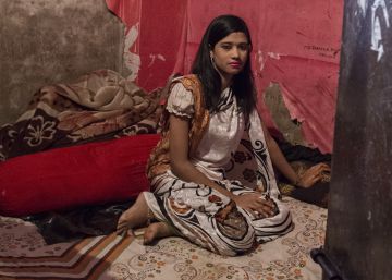 Shika posa en su vestido favorito sobre la cama en la que duerme y satisface a sus clientes.