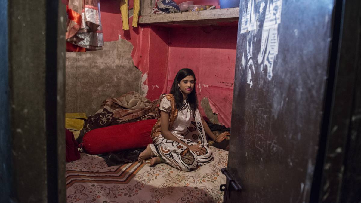 Shika posa en su vestido favorito sobre la cama en la que duerme y satisface a sus clientes.