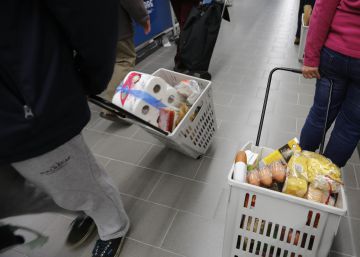 Varias personas haciendo la compra en un supermercado.rn rn 