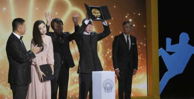 El director Xiaogang Feng alza la Concha de Oro.