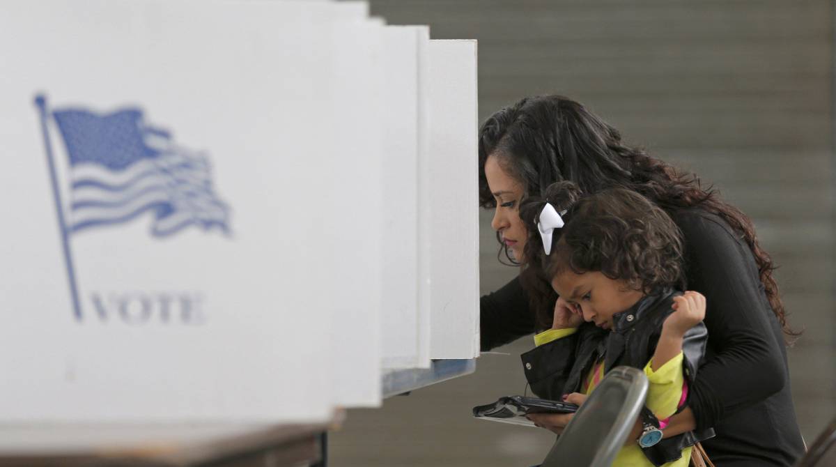 Betsy Argueta holds her daughter Isabella, 2, as she votes in the U.S. presidential election at the National Guard Armory in Smithfield, North Carolina, U.S. November 8, 2016. REUTERSChris Keane