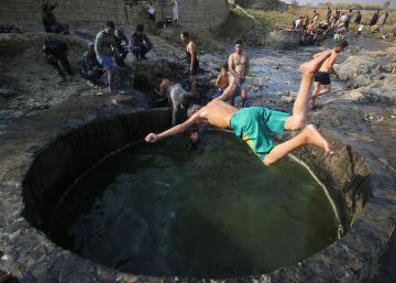 Iraqu&iacute;es se dan un ba&ntilde;o en un estanque de azufre junto a miembros de las fuerzas iraqu&iacute;es, en el Hamam al-Alil, a 14 kil&oacute;metros del sur de Mosul.rn 