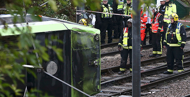 Policías junto al tranvia siniestrado en Croydon.
