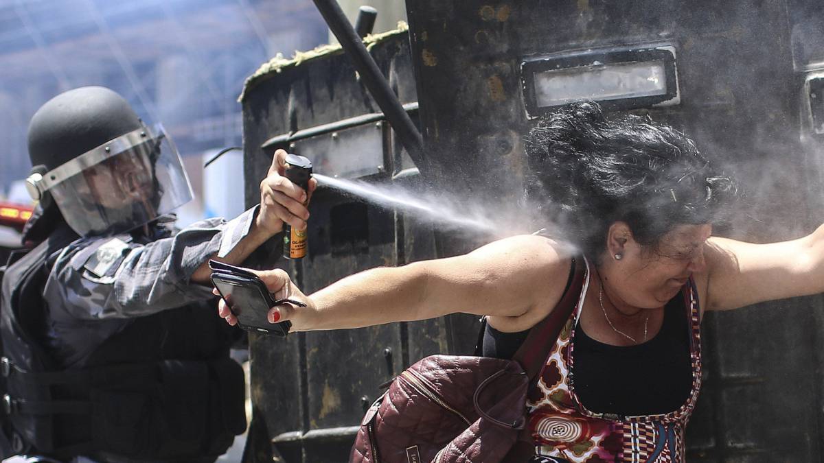 Un policía brasileño rocía con gas a una manifestante durante una protesta por el paquete de medidas del Gobierno contra los funcionarios públicos del estado de Río de Janeiro.