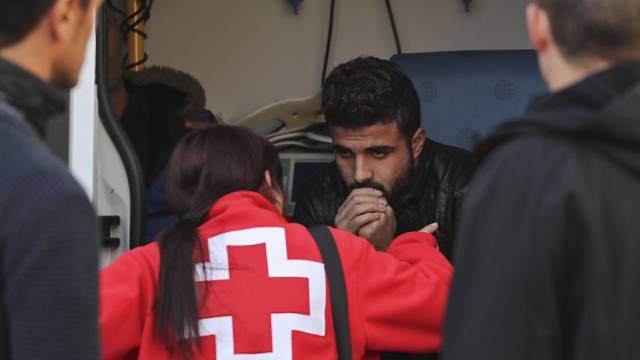 Trabajadores del SEM atienden a uno de los 10 refugiados hallados esta ma&ntilde;ana en Barcelona.