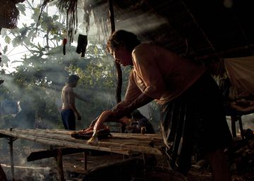 Mujeres y niñas se dedican a colocar en la cama los pescados que han sido salados en Sarayaku, Ecuador.