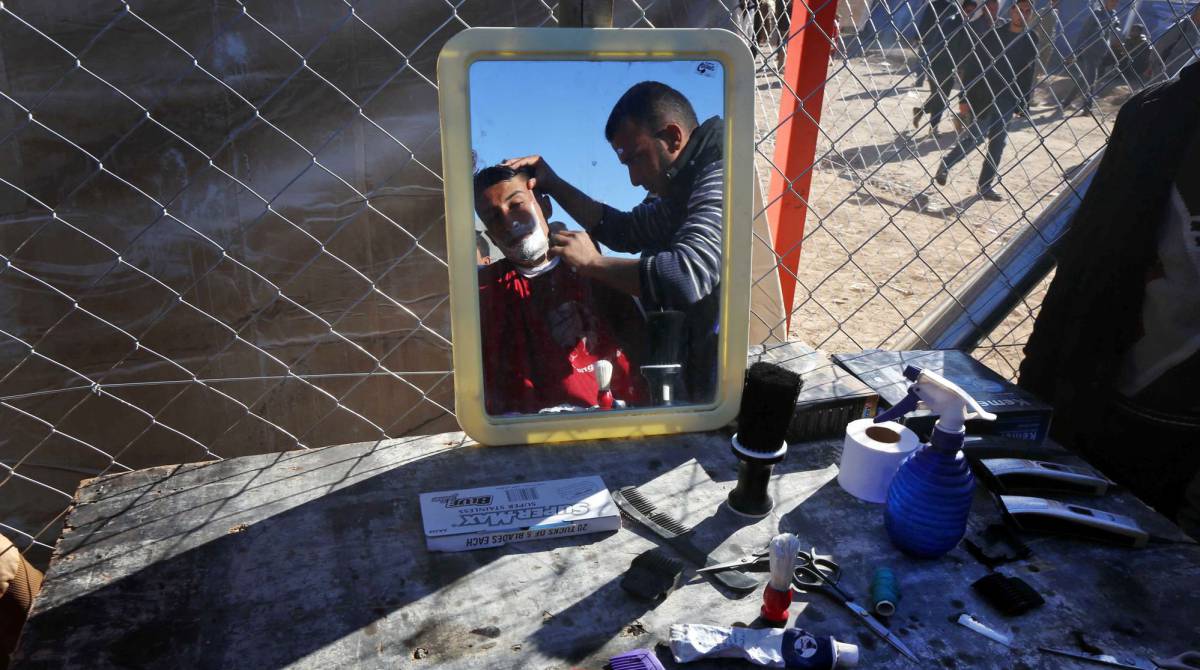 Un iraquí, que huyó de la violencia en Mosul, recibe un afeitado en un campo de desplazados de al-Khazar (Irak).