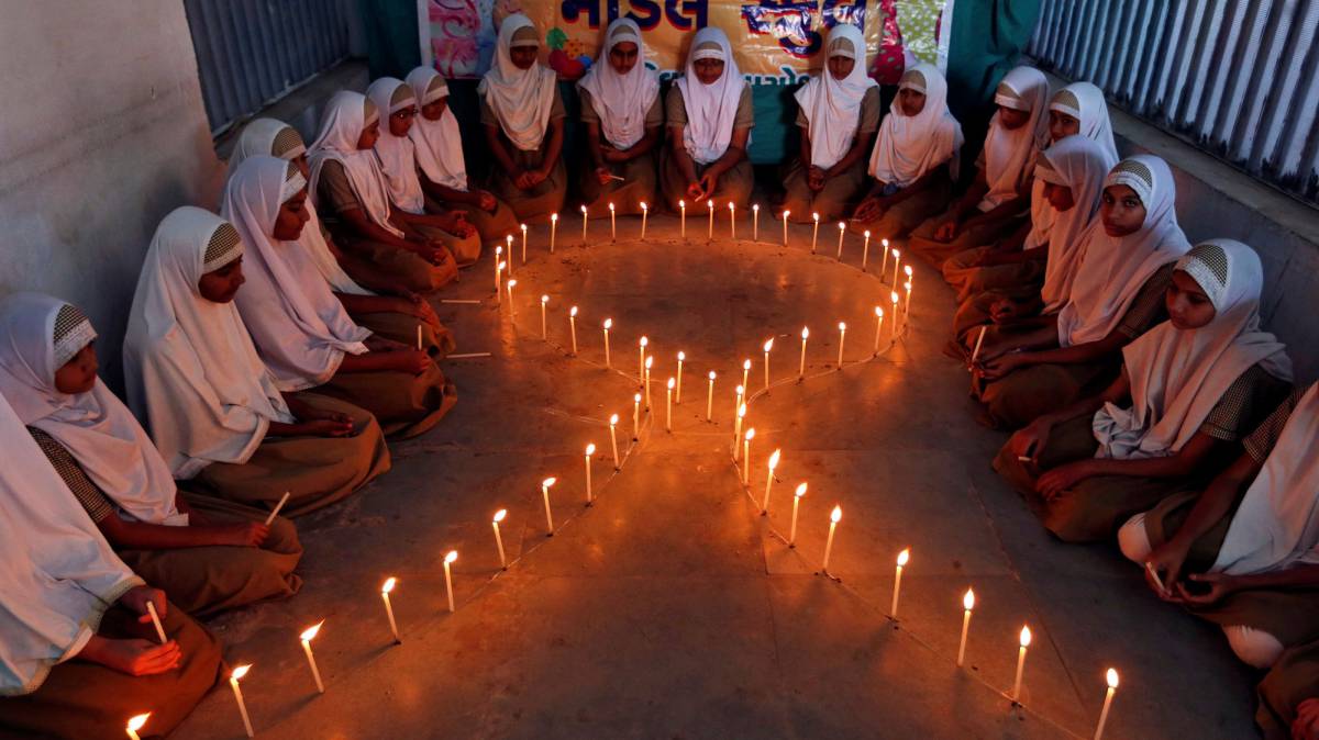 Alumnas de una escuela de Ahmedabad (India), encienden velas en forma de lazo, durante una campaña de sensibilización sobre el sida.