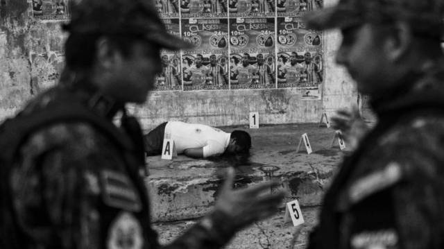 Policías mexicanos junto a un cadáver.