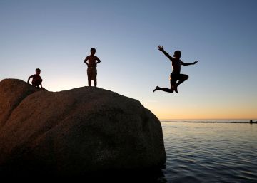Varios ni&ntilde;os saltan en una piscina, en Camps Bay (Sud&aacute;frica).rn rn 