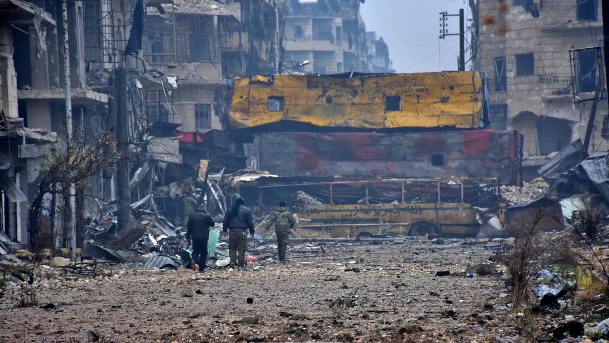 Guerrilleros sirios a favor del régimen pasean por el barrio Bustan al-Qasr, en Alepo (Siria).