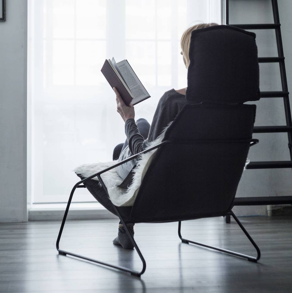 Persona leyendo sentada en un sillón.rn rn