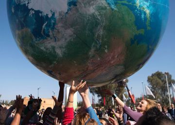 Asistentes a la COP222 juegan con un globo gigante que representa al planeta Tierra en Marrakech. 