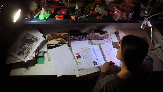 Una adolescente estudia en su cuarto.