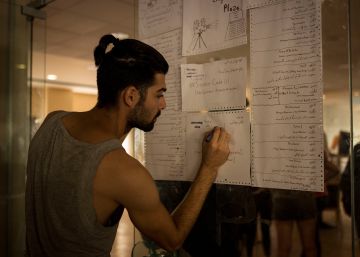 Rabi, un voluntario y huésped sirio, apunta una de las actividades para el jueves en la puerta del comedor principal del hotel.