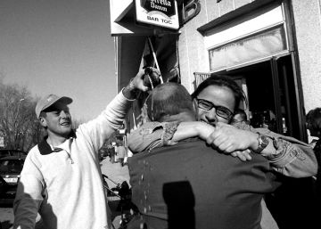 Dos hombres se abrazan en el exterior del bar de Balaguer, Lleida, d&oacute;nde ha tocado la loter&iacute;a.