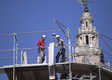 Dos obreros en un andamio en las labores de rehabilitaci&oacute;n de la fachada de la Catedral de Sevilla.