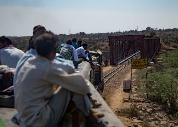 Un tren con el techo repleto de viajeros cruza el puente sobre el río Kuno, entre Gwalior a Sheopur, India.