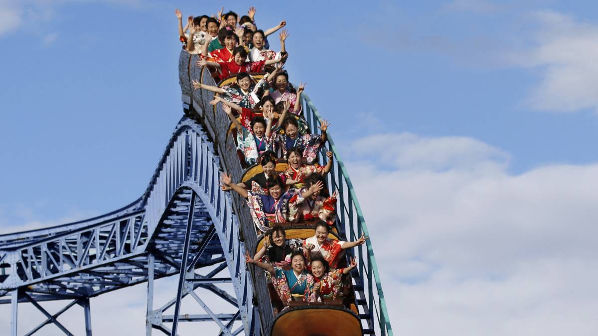Varias mujeres vestidas con kimonos celebran cumplir los 20 años de edad en una montaña rusa, en el parque de atracciones de Toshimaen, en Tokio (Japón).