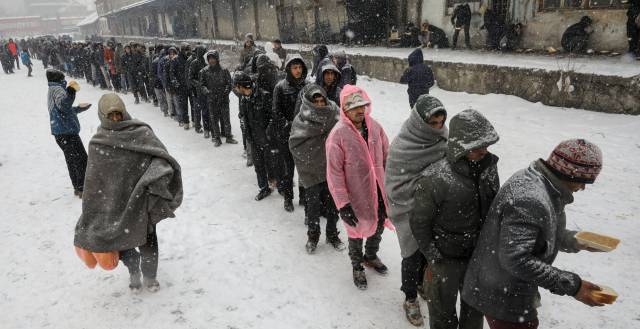 Migrantes hacen cola para recibir comida en Belgrado.