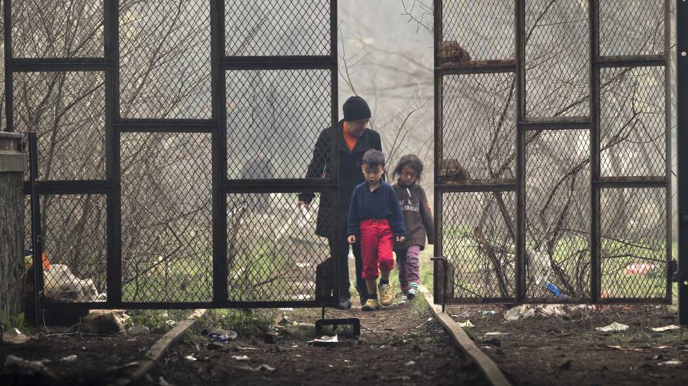 Una mujer y dos niños entran en un hangar donde se han instalado los refugiados en Idomeni, Grecia.rn