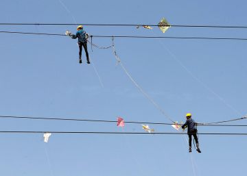 Varios trabajadores de una compa&ntilde;&iacute;a el&eacute;ctrica elimian cometas enredadas en cables de alta tensi&oacute;n, en Ahmedabad (India). 