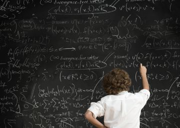 Un alumno frente a una pizarra con f&oacute;rmulas.