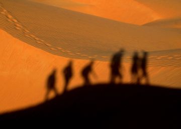 Las sombras reflejadas de un grupo de personas caminando por el desierto.rn Getty ImagesEyeEmrn 