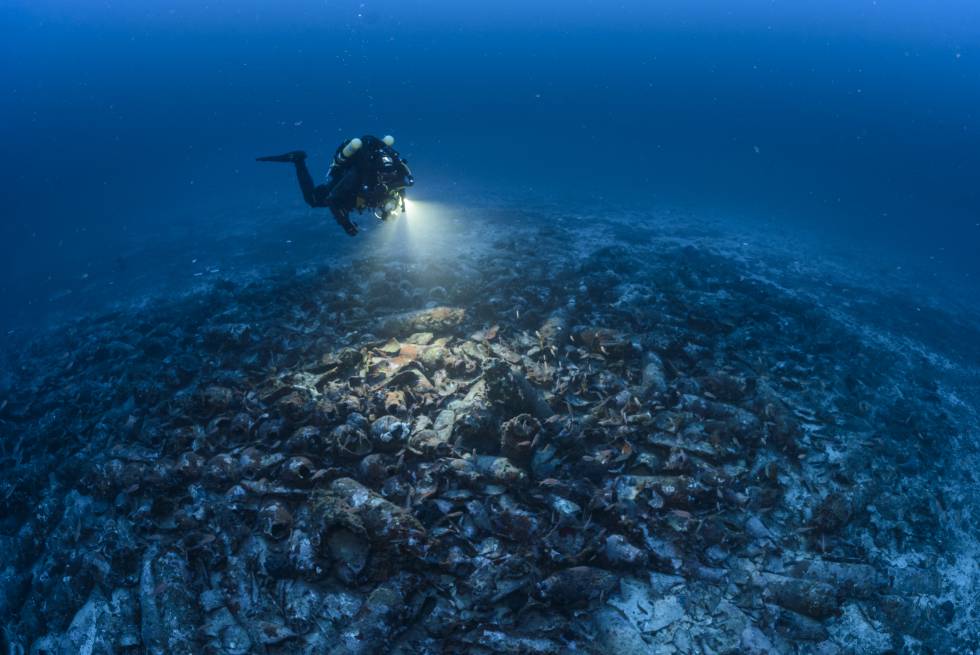 A Diver Examines The Remains Which Are Covered By Hundreds Of Amphorae A Diver Examines The Remains Which Are Covered By Hundreds Of Amphorae
