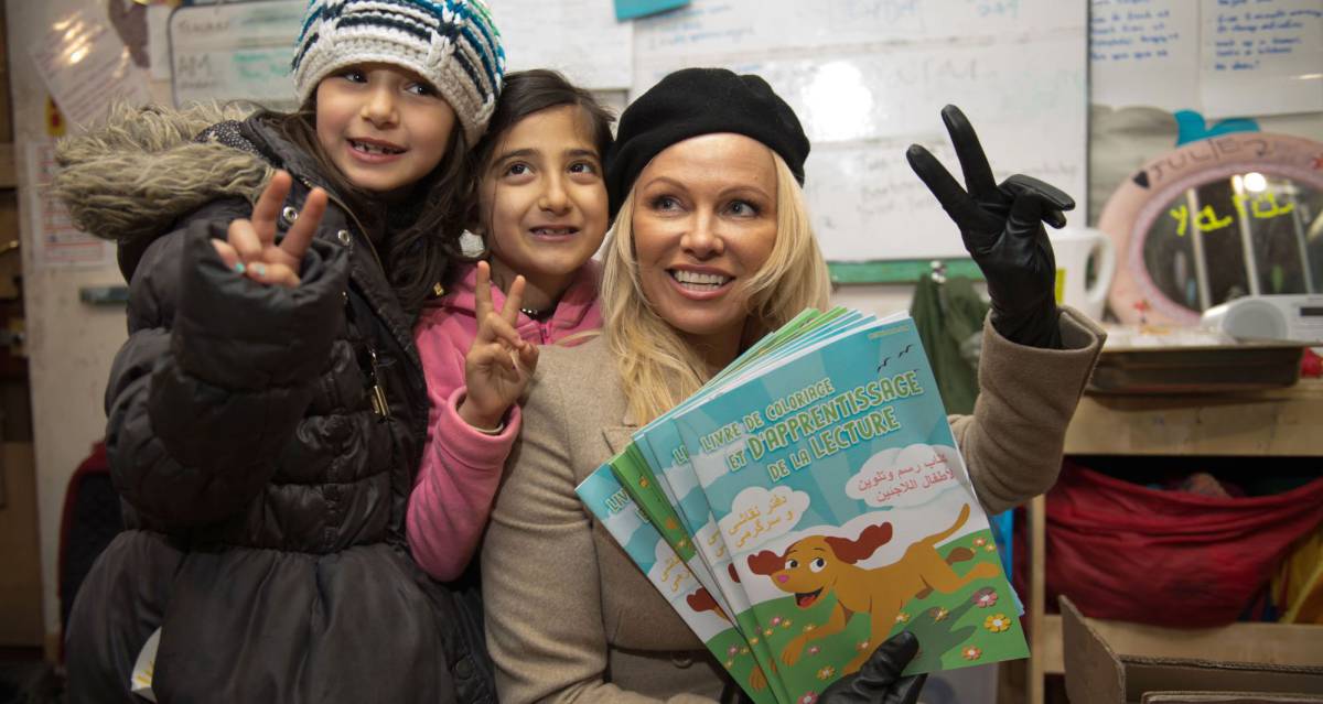 Pamela Anderson, junto a dos ni&ntilde;as en el campo de refugiados en Francia. 