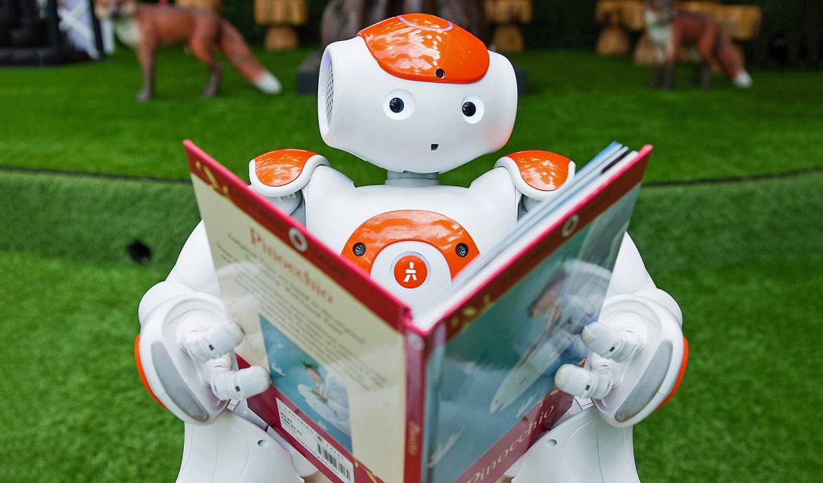 Un robot posa leyendo en Westfield, Londres.