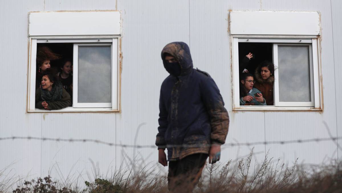Israeli settlers are seen inside their caravans as security forces gather at the Amona outpost, northeast of Ramallah, on February 1, 2017 to evict the hardline occupants of the wildcat settlement outpost in line with a High Court ruling that determined the homes were built on private Palestinian land.      Israeli police began evicting dozens of hardline Jewish settlers from a wildcat outpost, just hours after unveiling plans for 3,000 new homes in other West Bank settlements.    AFP PHOTO  Thomas COEX