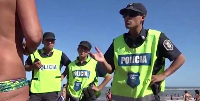 Police remonstrate with the topless women.