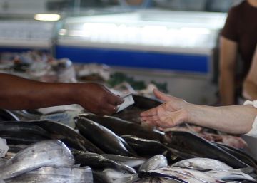 Una mujer recibe el cambio en el merdado de Benfica, en Lisboa.
