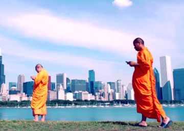 Plano de la película en la que unos monjes consultan sus teléfonos.