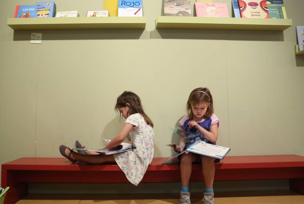 Feria del Libro de Madrid. Dos niñas miran libros en el pabellon infanti