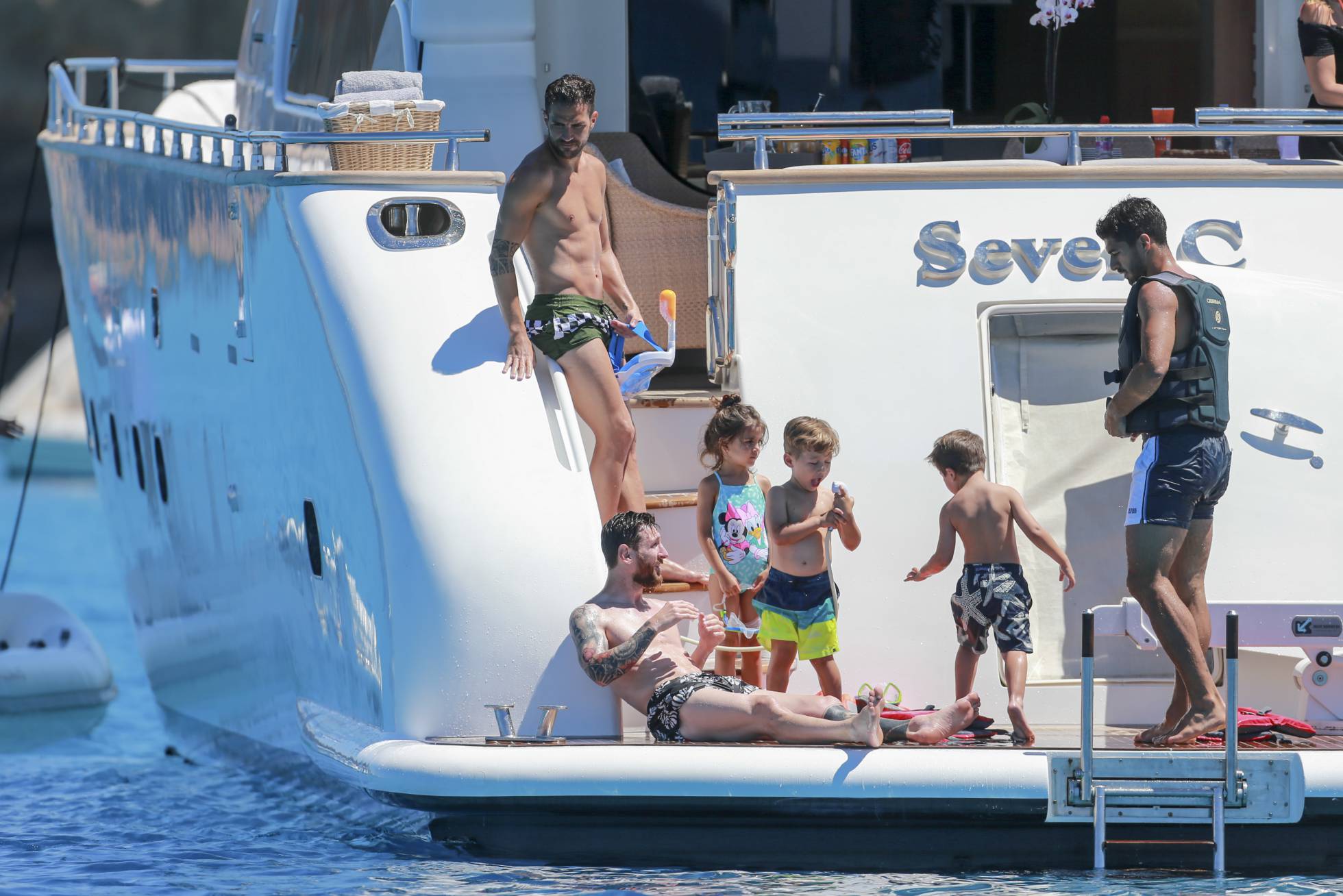 De izquierda a derecha, Cesc Fabregas, Lionel Messi y Luis Suarez con algunos de sus hijos durante las vacaciones en Ibiza a mediados de junio.